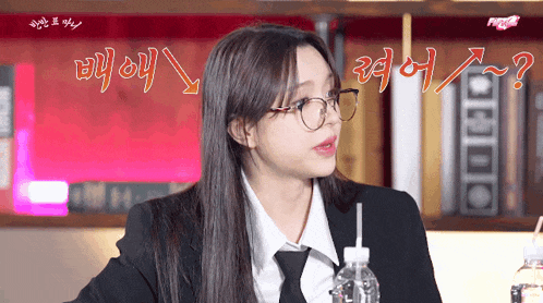 a woman wearing glasses and a suit with a straw in her mouth