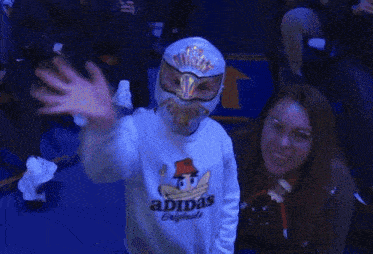 a person wearing a mask and an adidas sweatshirt