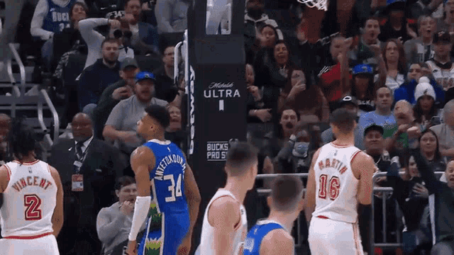a basketball game is being played in front of a crowd that is cheering for the bucks
