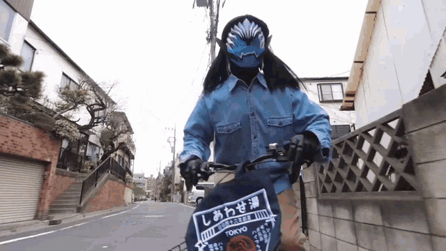 a person wearing a mask is riding a bike with a towel that says tokyo