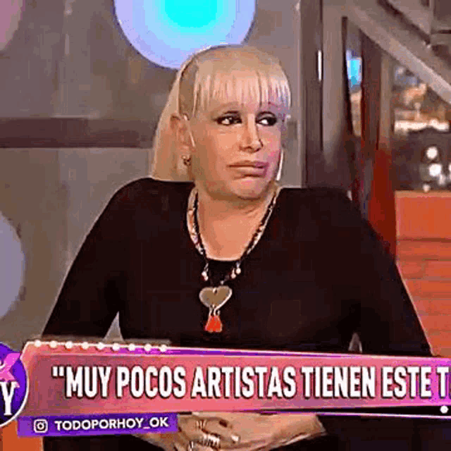a woman is holding a sign that says muy pocos artistas tienen este t