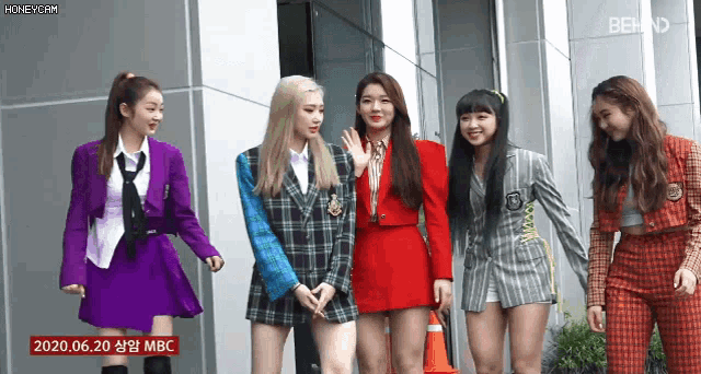 a group of girls are standing in front of a building with the date 2020 06.20