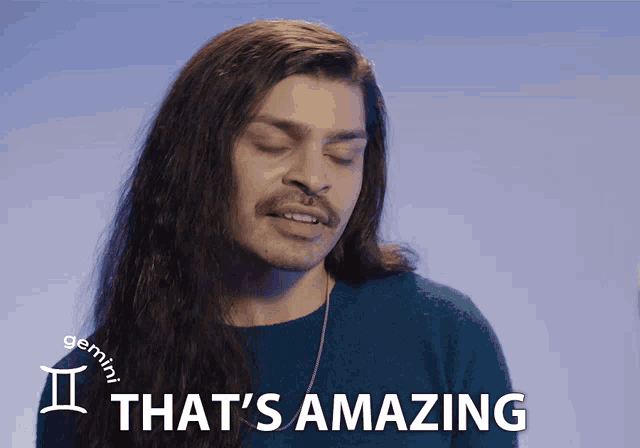 a man with long hair says " that 's amazing " in front of a blue background