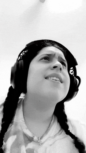 a woman wearing headphones and a necklace with a cross on it