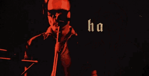 a man wearing headphones singing into a microphone with the words " ho ho ho " written on a red background
