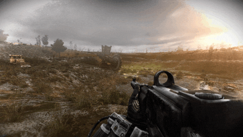 a person is holding a gun in a field with the sun shining through the clouds