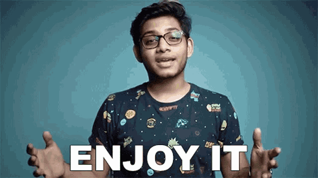 a young man wearing glasses and a t-shirt with the words enjoy it written on it .