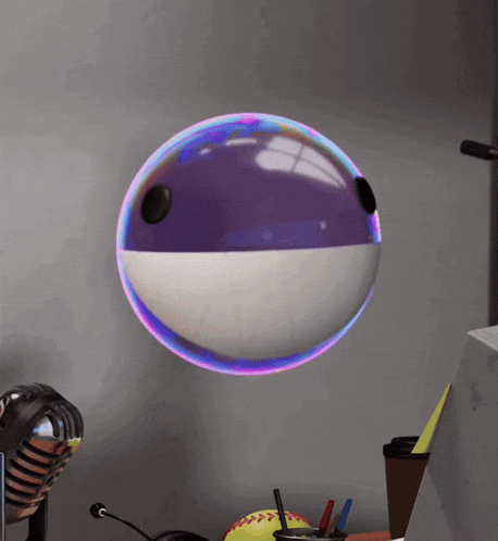 a purple and white ball is floating on a desk
