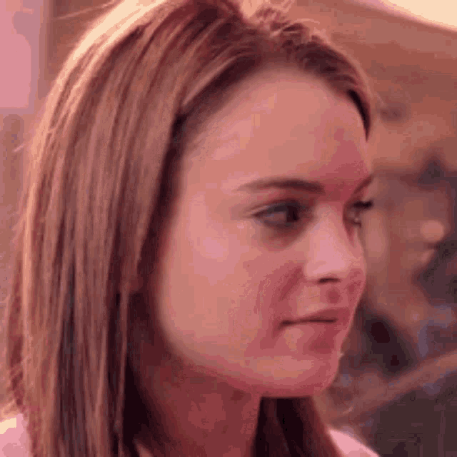 a close up of a woman 's face with long brown hair .