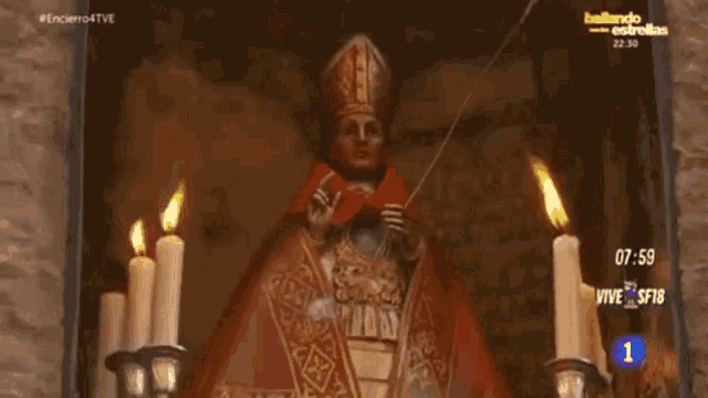 a statue of a bishop is surrounded by candles and a sign that says bailando estrellas