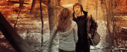 a man and a woman are standing in a forest