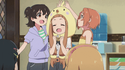 a girl wearing a yellow chicken hat is surrounded by two other girls