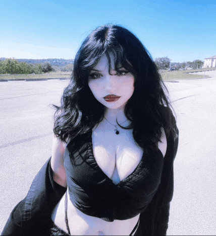 a woman with dark hair and red lips is wearing a black top