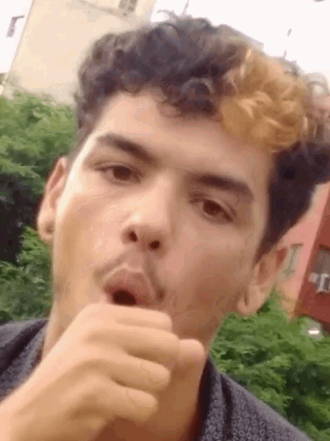 a man with curly hair and a mustache is making a funny face
