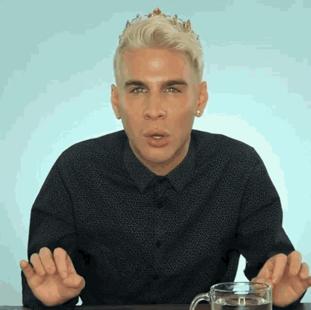 a man with a crown on his head holds a cup of water