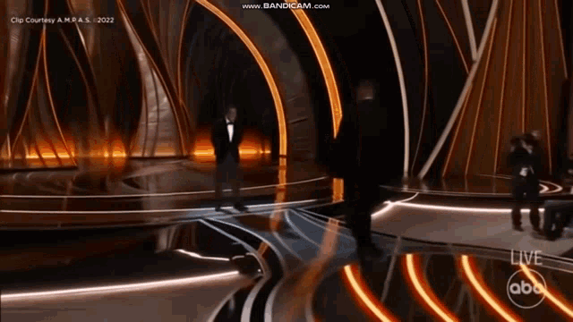 a man in a tuxedo is standing on a stage at an abc live show