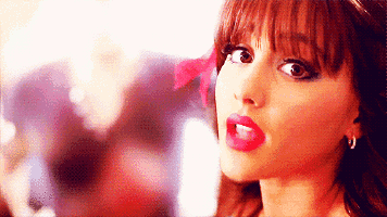 a close up of a woman 's face with red lipstick and earrings