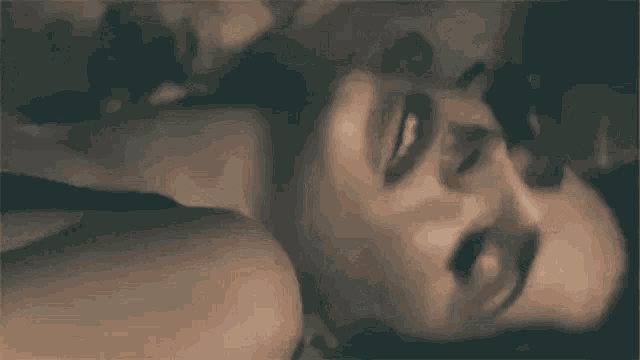 a man and a woman are kissing while laying on the floor .