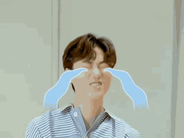 a man is crying with blue tears coming out of his eyes .