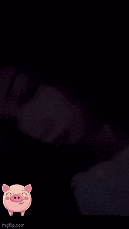 a close up of a woman 's face in the dark with a pig sticker on it .