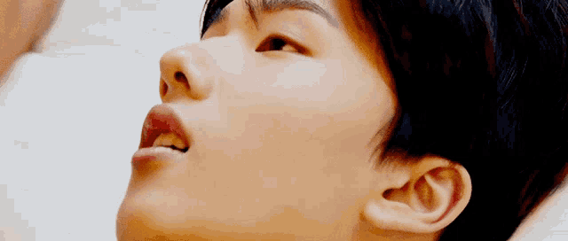 a close up of a person 's face with their eyes closed and their mouth open .