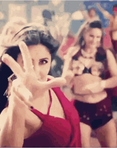 a woman in a red top is giving the peace sign