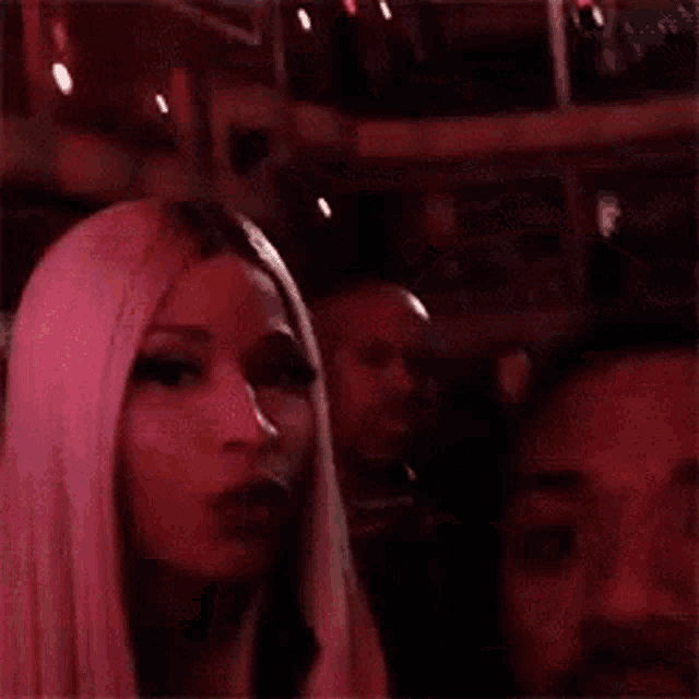 a woman is blowing a kiss on a man 's cheek .