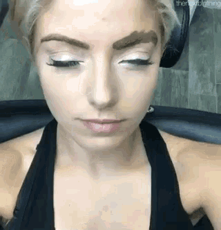 a close up of a woman 's face with her eyes closed and her eyebrows painted .