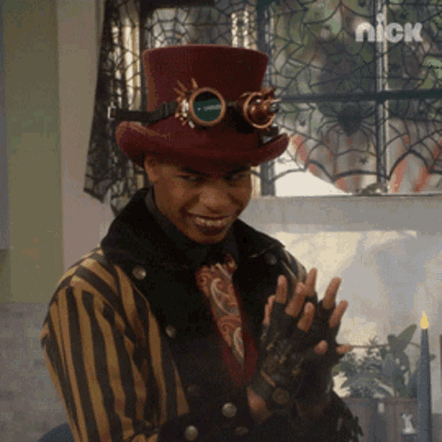 a man wearing a top hat and goggles is smiling in front of a window that says nick on it