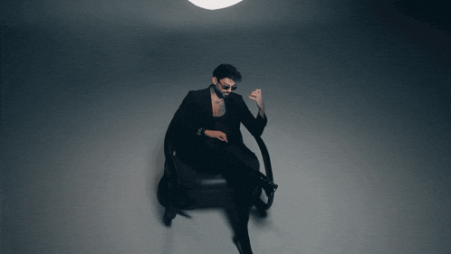 a man in a suit is sitting in a chair