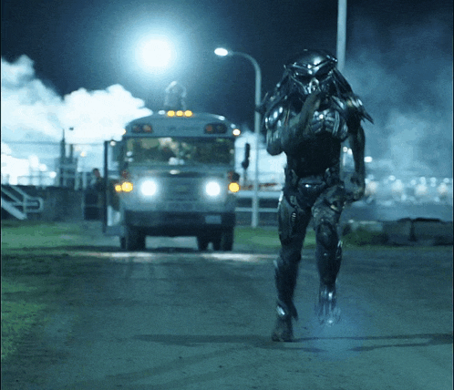 a predator is running towards a school bus at night