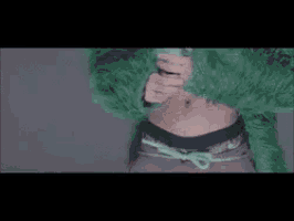 a close up of a person wearing a green fur coat and sunglasses .