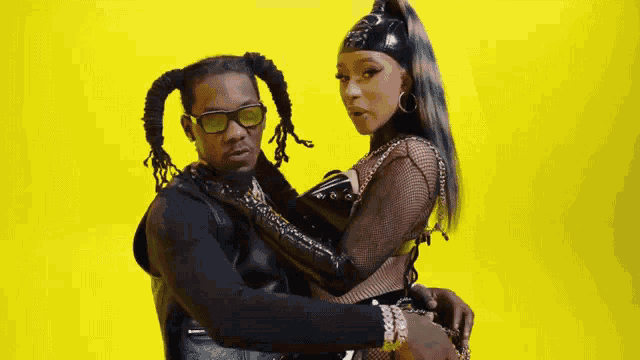 a man and a woman are posing for a picture against a yellow background .