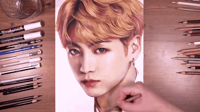 a drawing of a young man is surrounded by colored pencils and markers