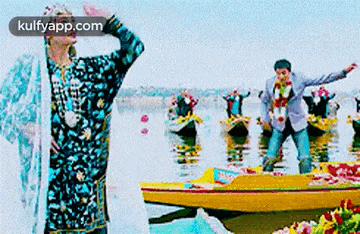 a man in a traditional dress is standing in the water next to a boat .