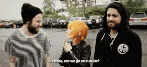 a man with a beard and a woman with orange hair are standing in a parking lot talking to each other .