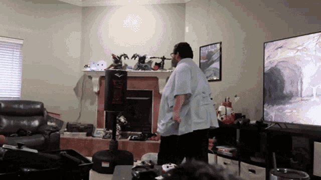 a man stands in front of a everlast punching bag in a living room