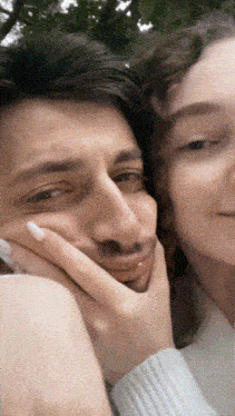 a woman holds a man 's face in her hand