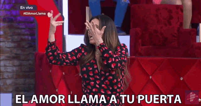 a woman in a red and black dress is screaming with the words el amor llama a tu puerta behind her