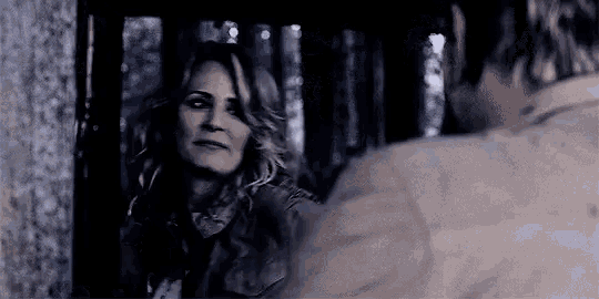 a man and a woman are looking at each other in the dark .