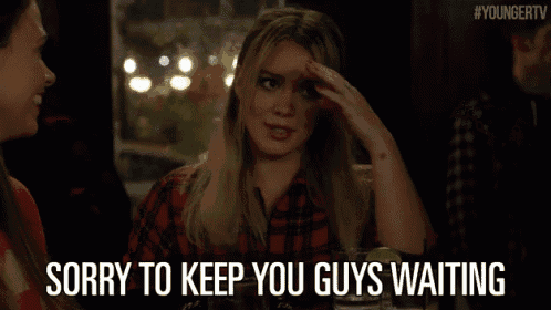 a woman says sorry to keep you guys waiting while sitting at a table with other people