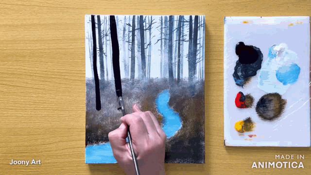 a painting is being painted on a wooden table with the words made in animatica on the bottom