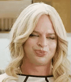 a close up of a person wearing a wig and making a funny face .