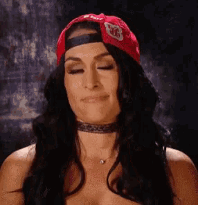 a woman is wearing a red hat and a choker .