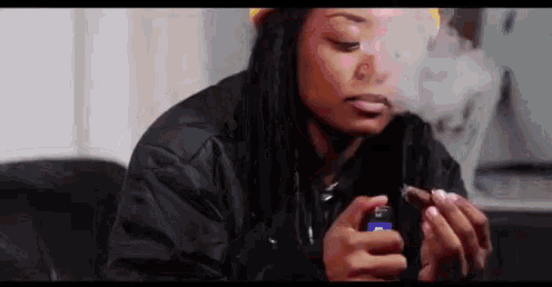 a woman with dreadlocks is smoking a cigar and blowing smoke out of her mouth