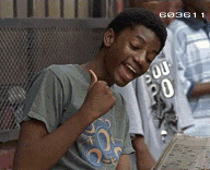 a young man is giving a thumbs up while looking at a book