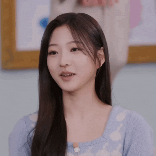 a young woman with long hair is wearing a blue and white sweater