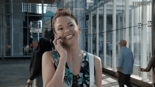 a woman is smiling while talking on a cell phone
