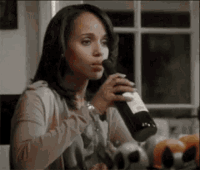 a woman is drinking wine from a bottle .