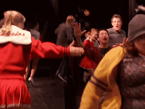a cheerleader in a red jacket with the letters l.a. on it
